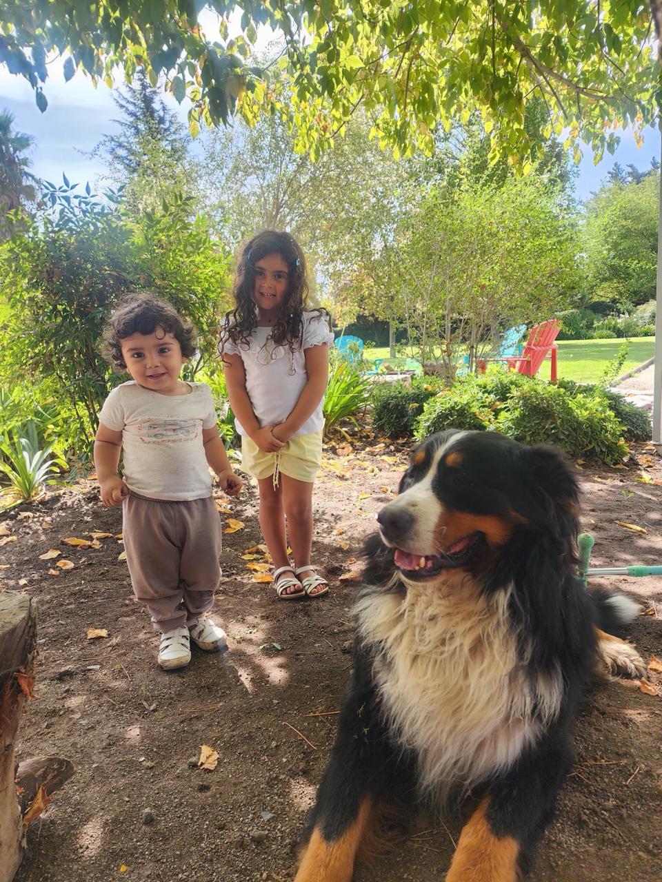 León y Agustina compartiendo junto a su perro en el jardín